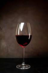 wine glass with red wine on a stone background
