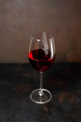 wine glass with red wine on a stone background