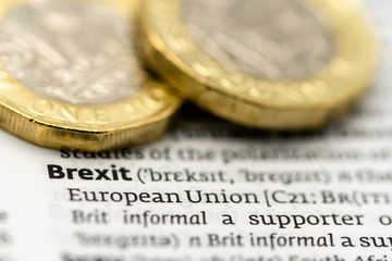 Definition of the word Brexit on a dictionary page with two pound coins