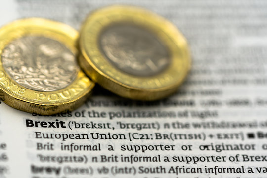 Definition of the word Brexit on a dictionary page with two pound coints