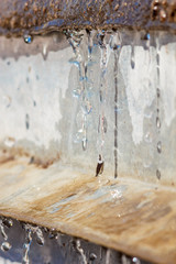 Close-up spring drops on the street in a large macro increase in the sunlight day. Soft and selective focus.