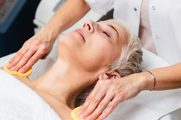 Obraz na płótnie Canvas Mature woman enjoying skin rejuvenation therapy at cosmetology center.