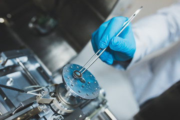 Researcher, scientist, physicist or laboratory assistant working, experimenting and analyzing in modern lab with equipments, tools and machines. - obrazy, fototapety, plakaty