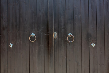 Rusty knockers on a wooden gates