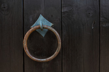Vintage door ring knocker on an entrance wooden door. Empty space