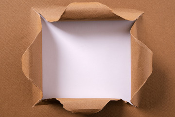 Torn brown paper square hole background frame