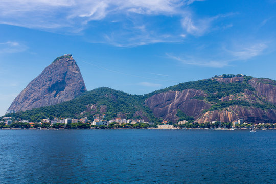 Beautiful panoramic view of the Sugar Loaf mountain in Rio de Janeiro, Brazil, on a beautiful and relaxing sunny day with blue sky and white clouds