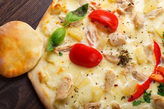 Close up smiling mouse face Italian pizza for children with melted cheese, chicken meat, red tomatoes and fresh green basil leaves on a brown table decorated by mushrooms, mozzarella and cherry. Emoji