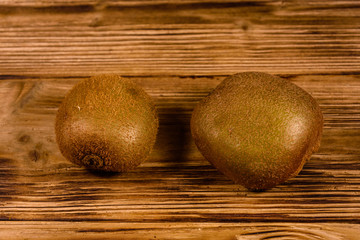 Two kiwi fruits on a wooden table