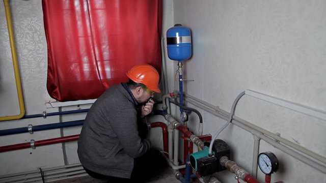 Technician inspecting heating system in boiler room