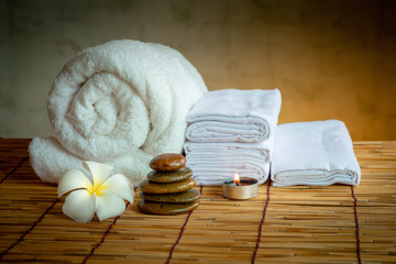 Obraz na płótnie Canvas Spa Oil Massaging Treatment and Skincare Concept., Component of Therapy Massage With Plumeria or Frangipani Flowers, Towel, Stones, Aroma Candle and Oil on The Desk.