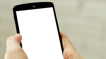 hands holding black mobile phone with white empty screen