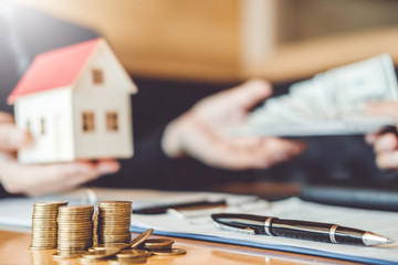 Customer giving Money Dollar bill  to Sale agent and sign agreement contract, Insurance Home concept