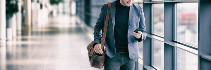 Business man texting on mobile phone commuting walking in airport with messenger bag using...