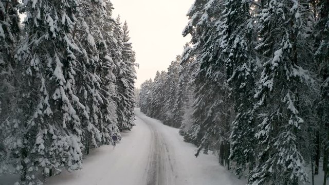 A speedy car running through the snowy road on an aerial view