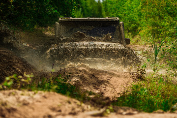 Mud and water splash in off-road racing. Tracks on a muddy field. Expedition offroader. Track on mud. 4x4 Off-road suv car. Offroad car. Safari. Rally racing.