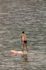 Stand up paddle board man paddleboarding . Young caucasian male model on Copacabana beach on summer holidays vacation trave