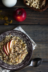 Fototapeta premium Buckwheat porridge with milk, apple, raisins and cashew nuts