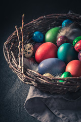 Quail and hen eggs for Easter in old wicker basket