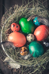 Closeup of Easter eggs with feathers and hay