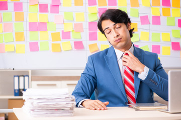 Young handsome employee with many conflicting priorities 