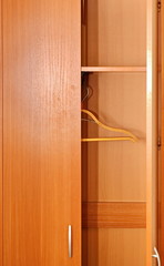 Fototapeta na wymiar Empty double-leaf home wooden wardrobe with open door and clothes hanger. Vertical frame