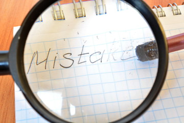 Rubber eraser on the tip of the pencil erases letter of word mistake written in report on a sheet...