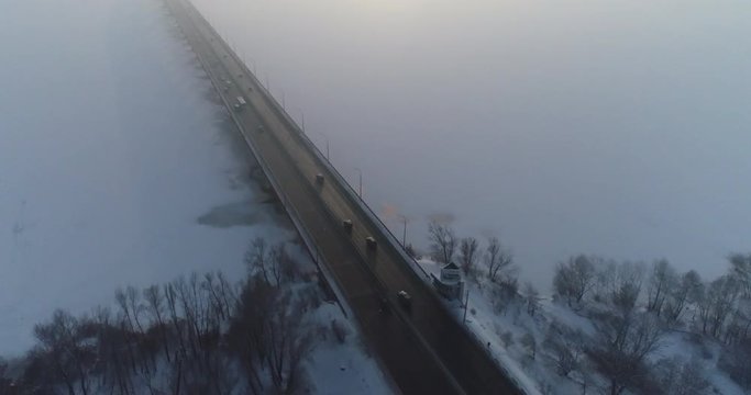 (original 4k file)  Flying over the road bridge in the fog with cars moving along it