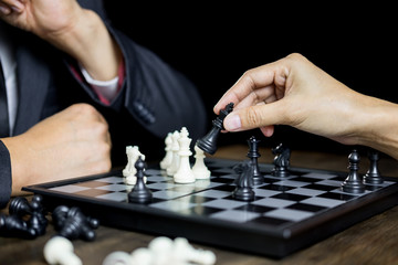 hand of businessman moving chess figure in competition board game for development analysis, strategy idea management or leadership concept.