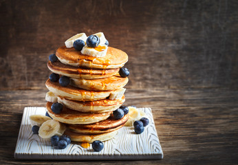 Pancakes with banana, blueberry and maple syrup for a breakfast