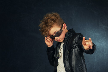 Studio portrait of a stylish boy in a leather jacket .
