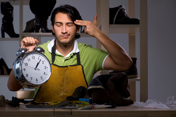 Young shoemaker in workshop at night 