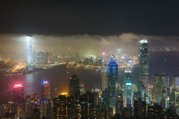 Misty night view of Victoria harbor in Hong Kong city