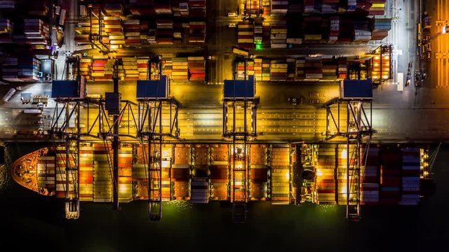 Container cargo freight ship with working crane bridge discharge at container terminal, Aerial top view container ship at deep sea port.