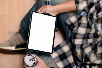 Top view young man using tablet while sitting on the floor.