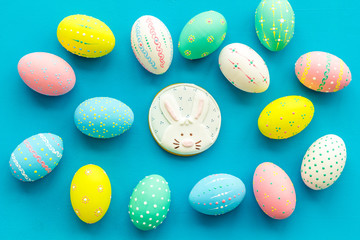 Colorful Easter eggs background and gingerbread on blue top view