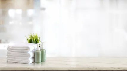 Fototapeten Handtücher mit grünem Keramikshampoo und Seifenflasche auf Marmortheke und Kopierraum © bongkarn