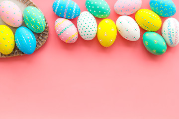Easter composition. Decorated pastel Easter eggs on pink background top view space for text