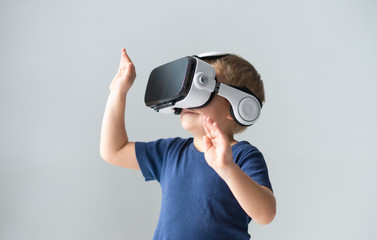 Portrait of happy boy in a virtual reality headset. Attractive kid using vr goggles at home. Entertainment technology and generation Z concept.