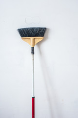 Close up of red black broom on white background