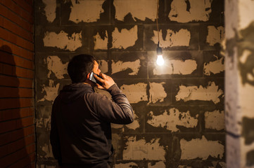 The man is talking on the phone and inspects the room. Man is making electricity. Restoration...