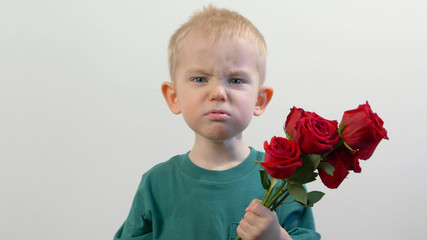 Cute kid ( two years old child)  holding the bouquet of red roses. Congratulations mother, womens, valentines day concept