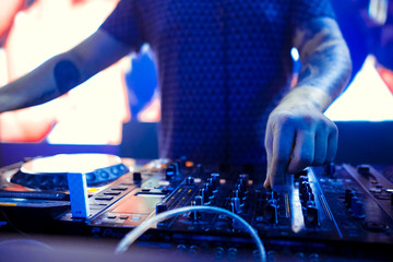 Dj mixing outdoor at beach party festival with crowd of people in background - Summer nightlife view of disco club outside