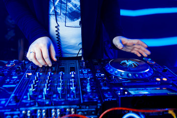Dj mixing outdoor at beach party festival with crowd of people in background - Summer nightlife...