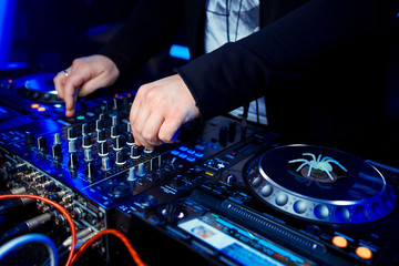 Obraz premium Dj mixing outdoor at beach party festival with crowd of people in background - Summer nightlife view of disco club outside