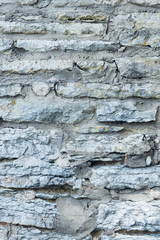 Old grey rough stone wall close-up texture background, selective focus, shallow DOF