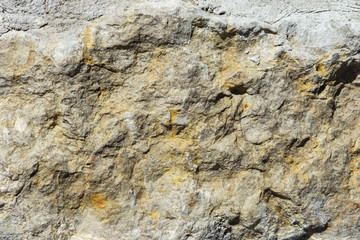 Old grey rough stone wall close-up texture background, selective focus, shallow DOF