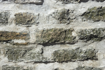 Old grey rough stone wall close-up texture background, selective focus, shallow DOF