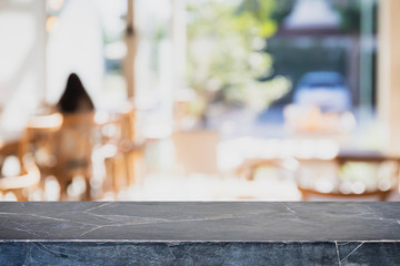 Empty black marble stone table top and blurred bokeh cafe and restaurent interior background with vintage filter - can used for display or montage your products.