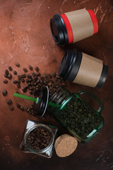 Takeaway coffee cups and coffee beans on a fire-warm rusty metal background, vertical shot, flatlay